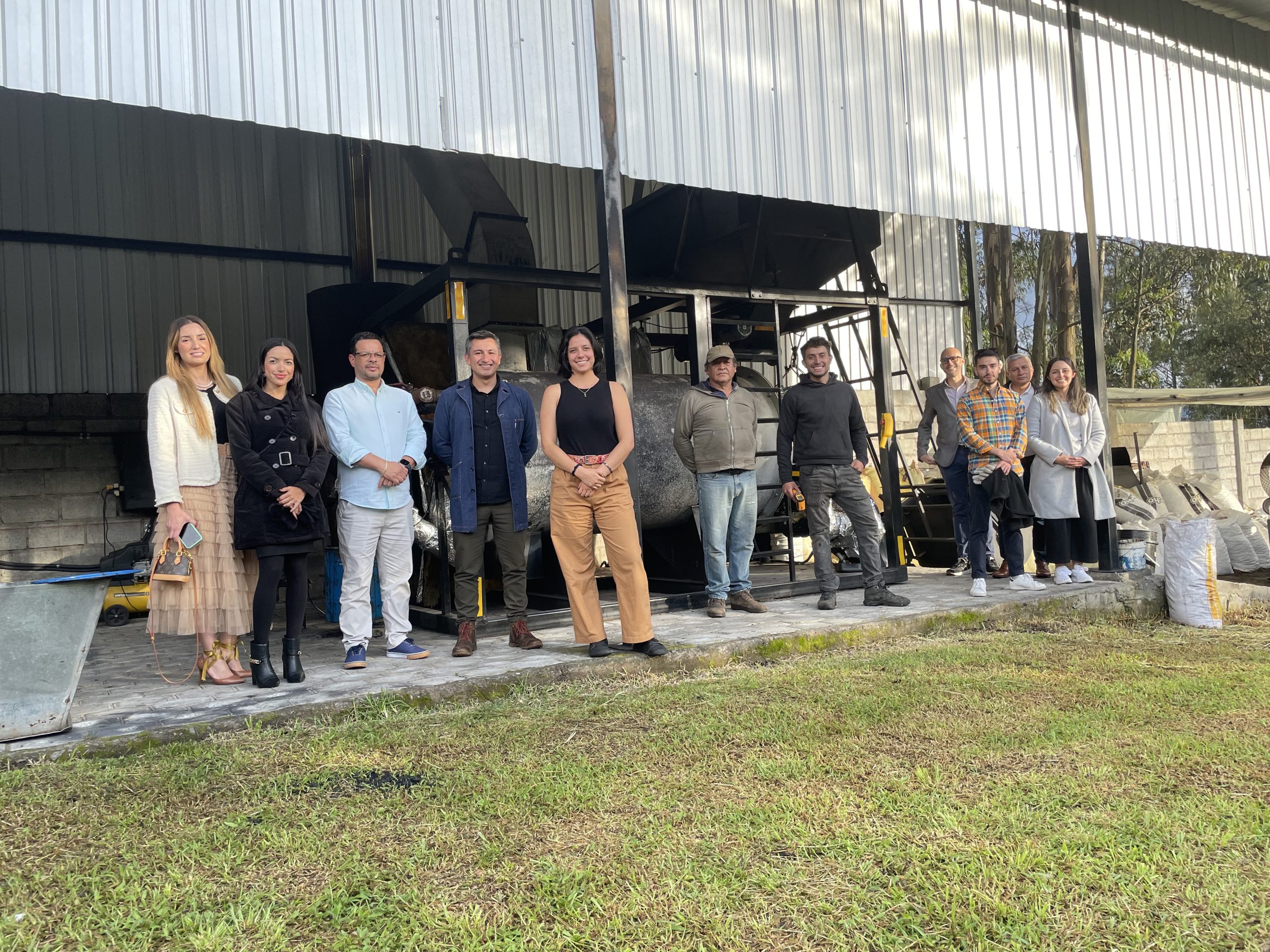 Nina Energy team and clients in front of a pyrolysis reactor at the plant.